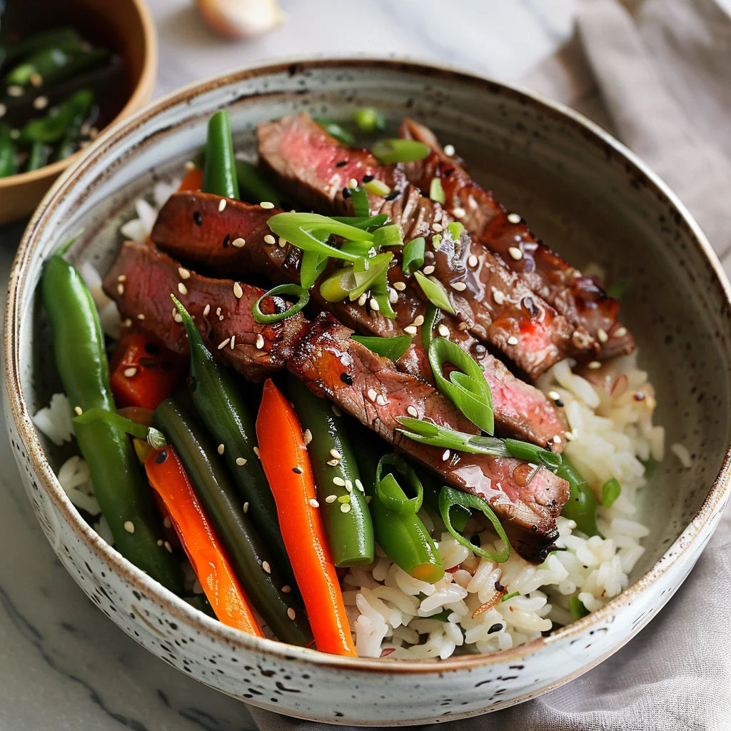 Bowl of rice with sliced beef, green beans, and carrots.